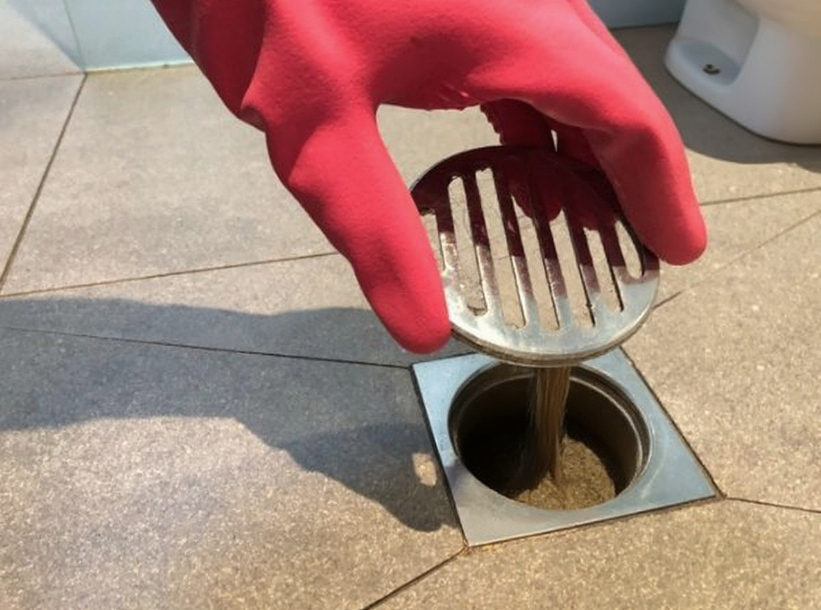 Técnico desentupindo ralo